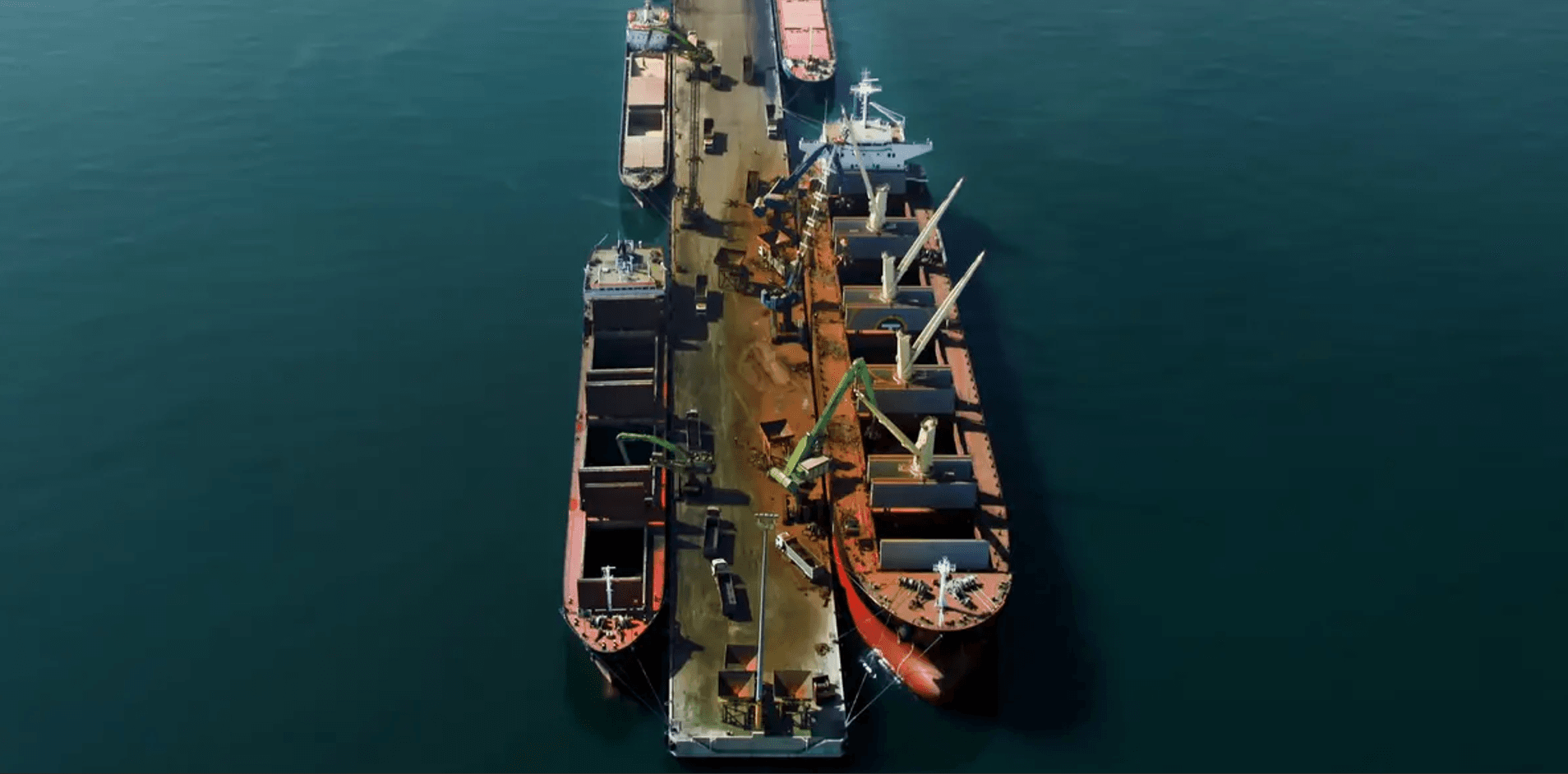 A fog cannon suppressing dust during the unloading of bulk material from a ship.