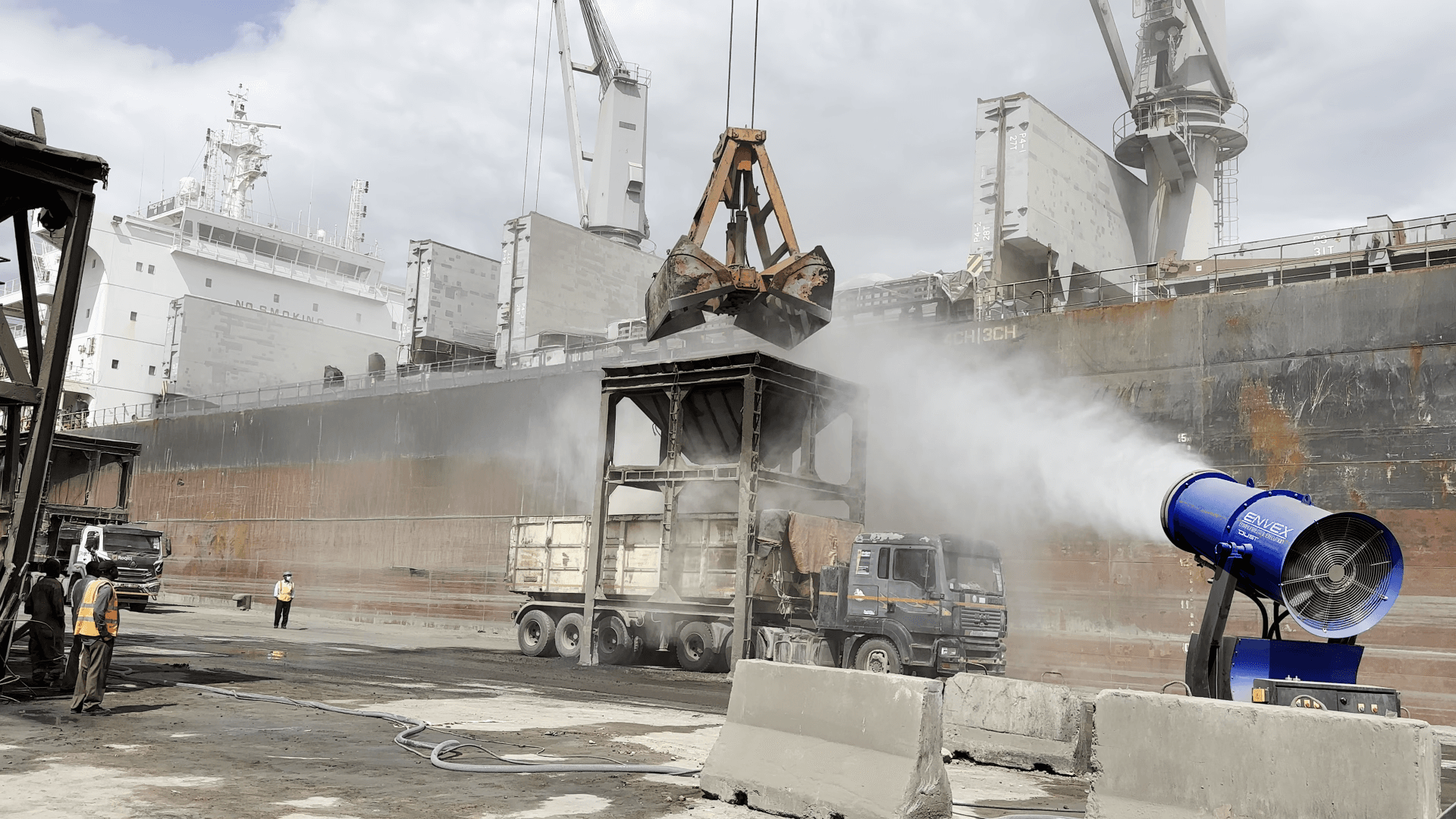 Dust control misting over a long conveyor belt system at a port.